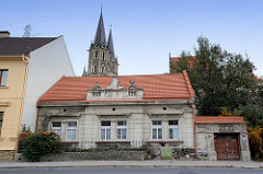 Altes Gebäude - Baustil der Gründerzeit mit klassizistischem Stuckdekor; im Hintergrund die Türme vom Dom in Kolín, St. Bartholomäus Kirche.