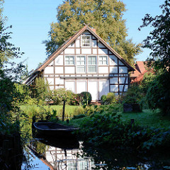 Fachwerkgebäude / Wohnhaus am Wasser, Spreekanal; Bootsanlegestelle mit Holzboot.