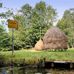 Ortsschild am Wasser - Spreekanal, Fliess / Lehde - Ledy, Stadt Lübbenau; Bootssteg und Heuschober auf der Wiese.