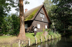 Traditionelles Holzgebäude - altes Wohnhaus mit Reet gedeckt - Fliess in Lübbenau.