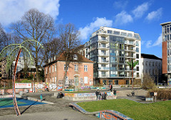 Parc fiction / Antonipark / Gezi-Park  in Hamburg St. Pauli; Metallpalme - Wohnhäuser, Gemeindehaus der St. Pauli Kirche.