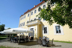 Schlossgebäude in Lübben (Spreewald); Restaurant mit Sonnenschirmen am Oberamtshaus.