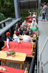 Ein Spreekahn mit Touristen an Bord in einer Schleuse in Schlepzig - das Boot passt gerade in die Schleusenkammer.