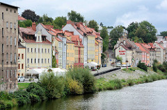 Wohnhäuser und Uferpromenade an der Neiße in Zgorzelec; polnischer Grenzpfahl am Ufer.