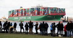 Schaulustige am Elbufer in Grünendeich blicken zum havarierten Containerfrachter CSCL Indian Ocean.