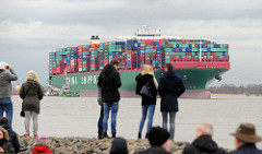 Schaulustige am Elbufer in Grünendeich blicken zum auf Grund gelaufenen  Containerschiff CSCL Indian Ocean.