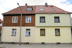 Siedlungshäuser mit Holz verkleidete Fassade; unterschiedlich farblich abgesetzte Fassadengestaltung - Architekturbilder aus  Wernigerode.