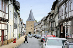 Fachwerkbebauung in Goslar, Breite Strasse - im Hintergrund das Breite Tor, Teil der historischen Stadtbefestigung aus dem 16. Jahrhundert.