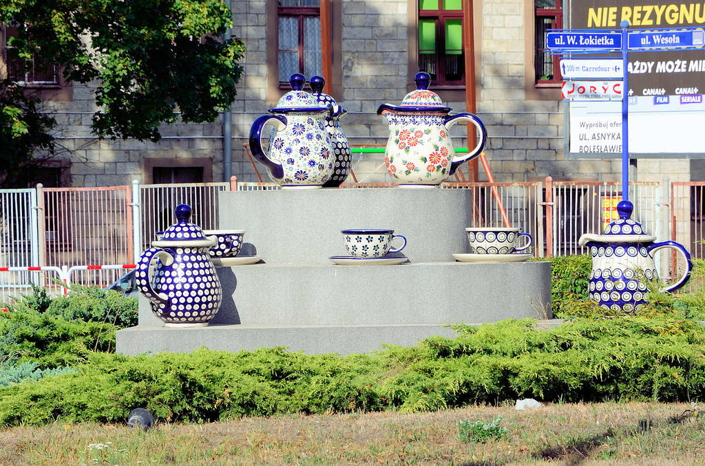 Stadt und Land Fotos: Foto „Überdimensionierte Bunzlauer Keramik Kannen und Tassen im Zentrum eines Kreisverkehrs in Bunzlau / Bolesławiec. Die Töpferei erlangte in der Stadt schon früh Bedeutung, bereits 1511 wurde die