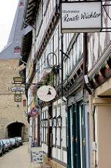 Fachwerkbebauung in Goslar, Breite Strasse - im Hintergrund das Breite Tor, Teil der historischen Stadtbefestigung aus dem 16. Jahrhundert.