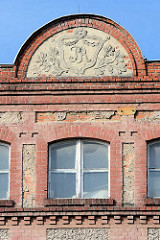 Historische Industriearchitektur in Striegau / Strzegom; Giebel eines Fabrikgebäudes - Jugendstilstuck, florale Dekoration - Monogramm Jugendstilbuchstaben.