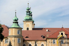 Kirchtürme der Minoritenkirche  St. Maria Kościół Matki Bożej Różańcowej in Kłodzko / Glatz; im Vordergrund das angrenzende Franziskanerkloster - Dachdecker bei der Arbeit.