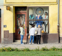 Modegeschäft in Striegau / Strzegom; drei Frauen stehen vor am Schaufenster und sehen sich die Auslage an.