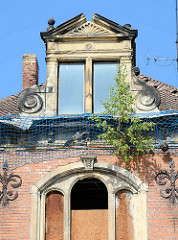 Verfallenes Mietshaus aus der Gründerzeit - junge Birken wachsen in der Dachrinne.
