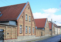 Architektur in Aschersleben - Ziegelhäuser, mit roten Ziegelbändern als Fassadengestaltung - Doppelhäuser mit Siedlungscharakter, hohe Ziegelmauer.