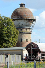 Wasserturm am Bahnhof von Aschersleben - Backsteinsockel mit Metallkuppel.