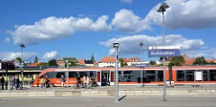 Bahnhof von Aschersleben - ein Zug ist in den Bahnsteig eingefahren, Fahrgäste mit Rädern steigen aus.