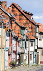 Fachwerkhäuser - Hausfassaden in Quedlinburg; Hauswände mit Dachziegeln verkleidet, moderne Strassenlaternen.