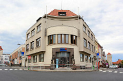 Gebäude der Tschechischen  Sparkasse / Česká spořitelna - Eckgebäude mit rundem Eingangsbereich mit Skulpturen - Architekturfotos aus Mělník.