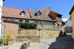 Fachwerkhäuser und enge Gassen mit Kopfsteinpflaster auf dem Münzenberg in Quedlinburg - ehem.  Sitz vom Beneditkinerinnenkloster und St. Marienkirche. Um 1539 wurde das Kloster aufgegeben  und ab 1580 von Handwerkern, fahrenden Leuten und Musiker