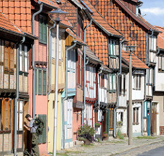 Fachwerkhäuser - Hausfassaden in Quedlinburg; Hauswände mit Dachziegeln verkleidet, moderne Strassenlaternen.