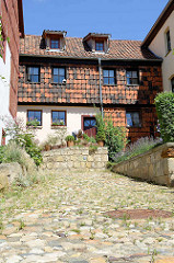 Wohnhaus und Kopfsteinpflaster auf dem Münzenberg in Quedlinburg - ehem.  Sitz vom Beneditkinerinnenkloster und St. Marienkirche. Um 1539 wurde das Kloster aufgegeben  und ab 1580 von Handwerkern, fahrenden Leuten und Musikern besiedelt. Die neuen