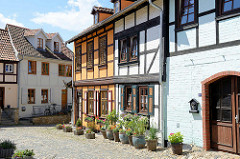 Fachwerkhäuser und enge Gassen mit Kopfsteinpflaster auf dem Münzenberg in Quedlinburg - ehem.  Sitz vom Beneditkinerinnenkloster und St. Marienkirche. Um 1539 wurde das Kloster aufgegeben  und ab 1580 von Handwerkern, fahrenden Leuten und Musiker