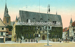 Historisches coloriertes Bild von Marktplatz in Quedlinburg - Blick auf das Rathaus mit Efeu bewachsen - hohe Kandelaber, Gaslaterne auf dem Platz; Pferdewagen und Passanten - lks. der Kirchturm der St. Benedikt / Marktkirche