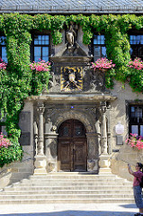 Eingang vom Quedlinburger Rathaus, die Fassade ist mit Kletterpflanzen bewachsen - das zweigeschossige gotische Gebäude ist eines der ältesten Rathäuser Mitteldeutschlands. Das Eingangsportal ist von Säulen gerahmt - über dem Portal befindet sich