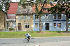 Schlichte einstöckige Wohnhäuser - farbige Fassade, grauer Putz - Radfahrer / Bilder aus Aschersleben.
