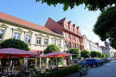 Wohn- und Geschäftshäuser am Marktplatz von Aschersleben - Café auf der Strasse mit Sonnenschirmen.