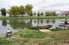 Ein Angler sitzt am Elbufer bei Králové / Königgrätz, Ausflugskähne am Steg - Blick auf das Gebäude Sokolovna, Sokol Philharmonisches Orchester - erbaut 1930, Architekt Milan Babuška.