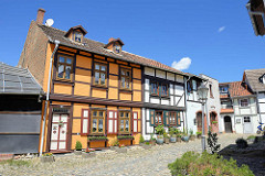 Fachwerkhäuser und enge Gassen mit Kopfsteinpflaster auf dem Münzenberg in Quedlinburg - ehem.  Sitz vom Beneditkinerinnenkloster und St. Marienkirche. Um 1539 wurde das Kloster aufgegeben  und ab 1580 von Handwerkern, fahrenden Leuten und Musiker