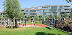 Neubauquartier, sogen. Marina auf der Schlossinsel im Harburger Hafen - Kinderspielplatz; re. abmontierte Baggerschaufel hinter einem Zaun.
