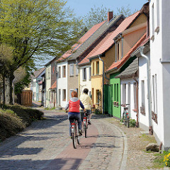 Gartenstraße in Barth, Kopfsteinpflaster auf Straße und Gehweg - Fahrradfahrerin.