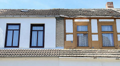 Detail Doppelhaus in der Bergstraße von Ribnitz-Damgarten; eine Hälfte restauriert, mit neuen Fenstern - die andere Hälfte renovierungsbedürftig, mit freigelegtem Fachwerk.