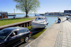 Öffentliche Slipanlage im Hafen von Ribnitz-Damgarten; ein Motorboot wird gerade geslippt / zu Wasser gelassen.