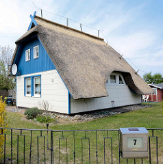 Ferienhaus mit Reetdach - ausgespart am Seitenfenster, im Dachgeschoss blaue Holzfassade / Ostseebad Ahrenshoop.