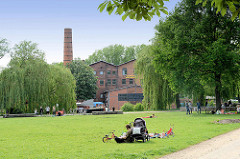 Wiese / Liegewiese am Ende vom Veringkanal in Hamburg Wilhelmsburg - im Hintergrund die Honigfabrik; 1906 als Magarinefabrik erbaut - jetzt Kulturzentrum.