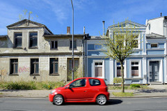 Architektur in Ribnitz-Damgarten, Bahnhofsstraße - restauriertes Wohnhaus mit blauer Fassade, weiss abgesetzten Fensterlaibung -  verlassenes Wohnhaus, gleiche Bauform wie das Nebengebäude, verfallene Hausfassade - alt + neu.