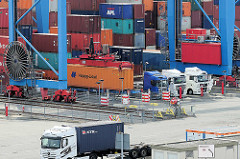 Sattelschlepper / LKW stehen unter dem Portalkran auf dem Gelände vom Hamburger Container Terminal Altenwerder.