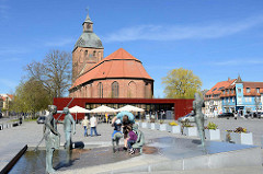 Brunnen Bernsteinfischer mit Familie am Marktplatz von Ribnitz-Damgarten; Bildhauer Thomas Jastram, 2007. Im Hintergrund die Marienkirche, ursprünglich dreischiffige spätromanische Hallenkirche aus dem 13. Jahrhundert - mehrmaliger Umbau; quadrat