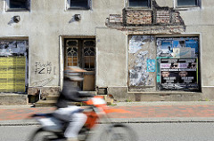 Verlassenes Wohnhaus in Ribnitz-Damgarten; abbröckelnder Putz legt altes Fachwerk und Ziegelsteine frei - schnell fahrendes Motorrad.