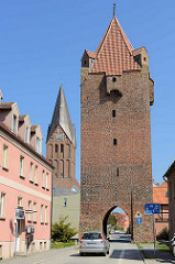 Dammtor, historische, mittelalterliche Befestigungsanlage in Barth; daneben der Kirchturm der Barther St. Marienkirche.