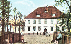 Das alte Hannoversche Amtshaus Wilhelmsburg wurde 1724 auf den Grundmauern der Grotenburg errichtet. 1865 wird das Gebäude verkauft und als Kirchdorfer Schule genutzt. Kinder kommen aus dem Gebäude und stehen auf dem Schulhof.
