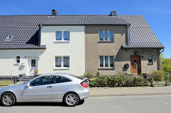 Schlichtes einstöckiges Wohnhaus, symmetrisch mittig geteilt, grauer Rauhputz und weiße Hausfassade  - Klüßenberg in Ribnitz-Damgarten.