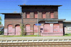 Geschlossener Bahnhof von Ribnitz-Damgarten Ost - Fenster und Türen des Backsteingebäudes mit Holzplatten verschlossen.