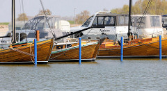 Marina im Osthafen von Barth - Zeesboot Anna und weitere historische Holzboote, dahinter Motorboote / Kajütboote.