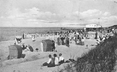 Historisches Motiv vom  Ostseebad Zingst - Sandburgen mit Strandkörben, Badegäste am Strand; im Hintergrund die Seebrücke.