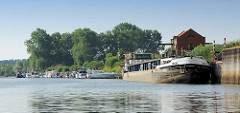 Hafen von Bleckede an der Elbe; das Binnenschiff IDEAL liegt am Kai - im Hintergrund die Marina / Sportboothafen mit Motorbooten.